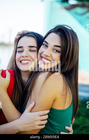 Due migliori amici femminili che si abbracciano insieme all'aperto Foto Stock