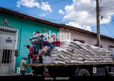 Persone che saltano di un camion che trasporta sacchi di cibo, Trinidad, Cuba Foto Stock