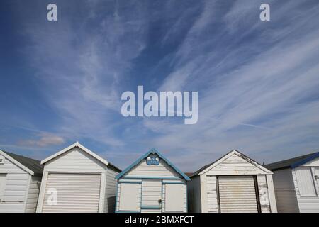 Una fila di capanne sulla spiaggia a Thorpe Bay, vicino a Southend-on-Sea, Essex. Foto Stock