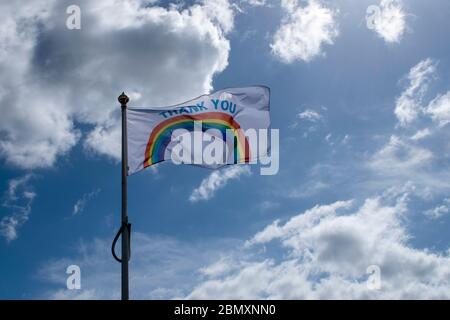 Grazie bandiera arcobaleno per i lavoratori NHS e Care che si battono nella brezza in una calda giornata di primavera soleggiata in Inghilterra. Foto Stock