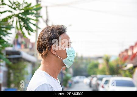 L'uomo asiatico indossa una maschera per prevenire la polvere a Bangkok, Thailandia. Foto Stock