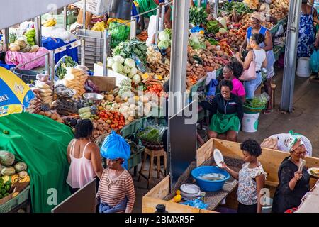 Bancarelle con frutta fresca e verdure in vendita al mercato alimentare indoor occupato nella città di Praia sull'isola di Santiago, Capo Verde / Cabo Verde Foto Stock
