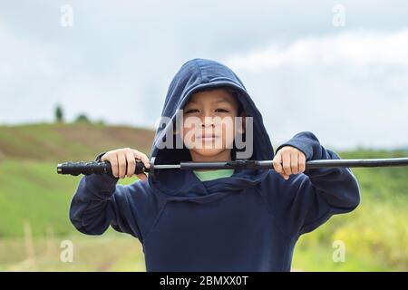 Ritratto di ragazzo Asean tenendo un di legno giochi di spada. Foto Stock