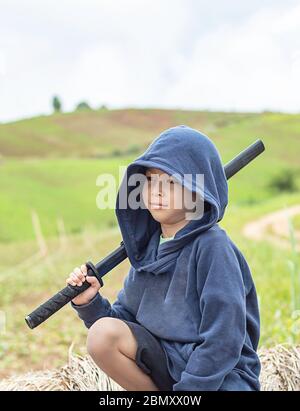 Ritratto di ragazzo Asean tenendo un di legno giochi di spada. Foto Stock