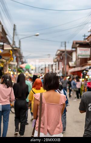 Donna sulla strada e sfocata i turisti a Walking Street Chiang Khan, Loei in Thailandia. Foto Stock