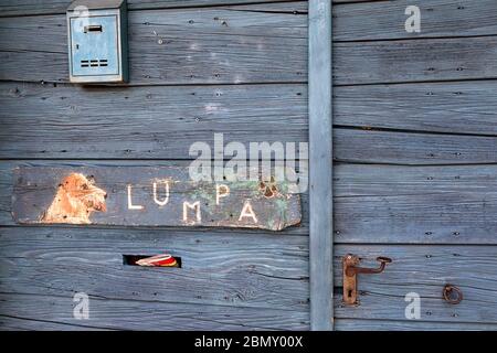 Divertente segno del cane sulla porta di ingresso in legno blu Foto Stock