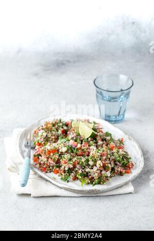 Insalata di Quinoa Quinua con pomodori ed erbe in ciotola bianca Foto Stock