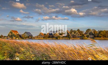 Tradizionale scenario di villaggio con case in legno sul lungomare a Groot Schermer, Olanda del Nord, Paesi Bassi Foto Stock