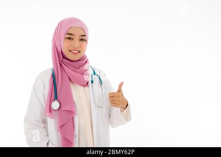 Ritratto di donna musulmana medico in hijab dando un pollice in su con sorriso bello, sfondo bianco isolato con spazio di copia Foto Stock