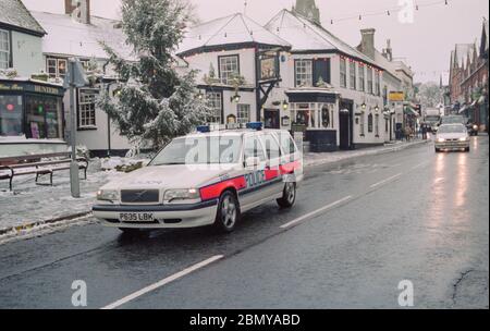 Hampshire Constabulary ha segnato auto di polizia in pattuglia in Lyndhurst High Street, Lyndhurst, New Forest durante una caduta di neve invernale, Lyndhurst, New Forest, Hampshire, Inghilterra, Regno Unito Foto Stock