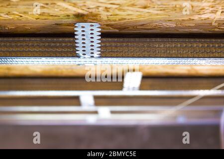 Profilo di montaggio a secco su piastra truciolare. Installazione di scheletro da soffitto non rifinito Foto Stock