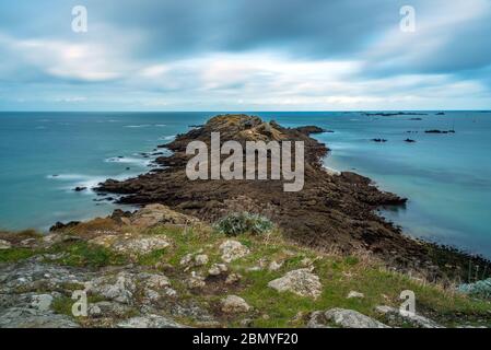 Vista di un promontorio roccioso sull'oceano Atlantico. Situato in Bretagna, Francia. Il nome di questo capo è Pointe du décollé. Shot con una tecnica di esposizione lunga. Foto Stock