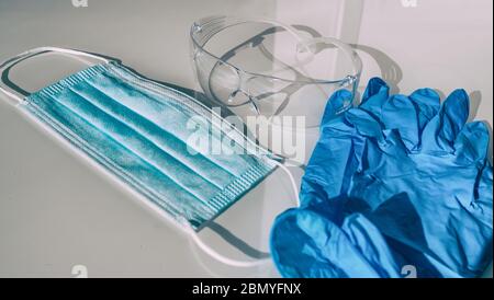 PPE COVID-19 maschera, guanti, occhiali di protezione per operatori sanitari. Mancanza di dispositivi di protezione individuale per il coronavirus Foto Stock