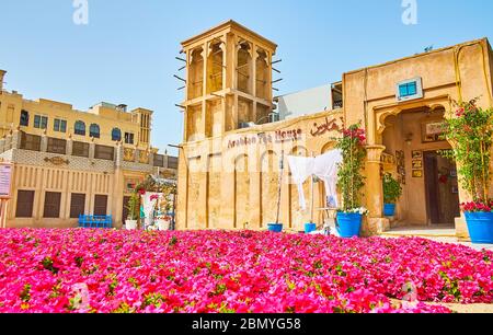 DUBAI, Emirati Arabi Uniti - 2 MARZO 2020: Il tappeto-come petunia letto fiore di fronte alla casa del tè arabo, situato in un edificio d'epoca in argilla con barjeel windcatche Foto Stock