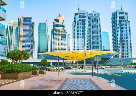 DUBAI, Emirati Arabi Uniti - 2 MARZO 2020: Il futuristico parco della stazione della metropolitana Damac Properties di fronte al lussuoso complesso Jumeirah Lake Towers, il 2 marzo nel Foto Stock