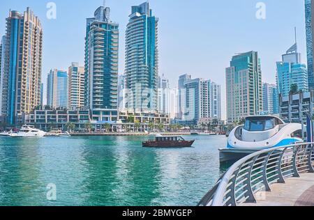 DUBAI, Emirati Arabi Uniti - 2 MARZO 2020: Il moderno traghetto è ormeggiato sulla riva di Dubai Marina con una vista sui grattacieli moderni sullo sfondo, il 2 marzo in Foto Stock