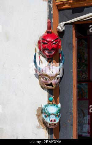 Bhutan, Punakha. Sopsokha villaggio. Maschere tradizionali appese alla parete del negozio. Foto Stock