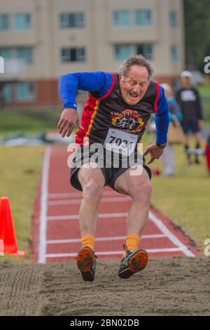 In competizione nel salto lungo senior maschile, atterrando. 70 anni. Foto Stock