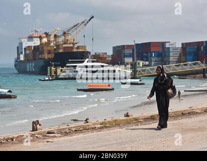 Zanzibar, Tanzania : donna musulmana in abito tradizionale nel porto di Zanzibar Foto Stock