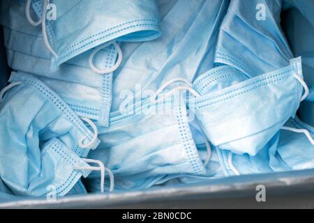 Sfondo delle maschere mediche protettive usate. Mascherine blu dopo l'uso. Maschere mediche che utilizzano. Utilizzo di maschere usate. Foto Stock