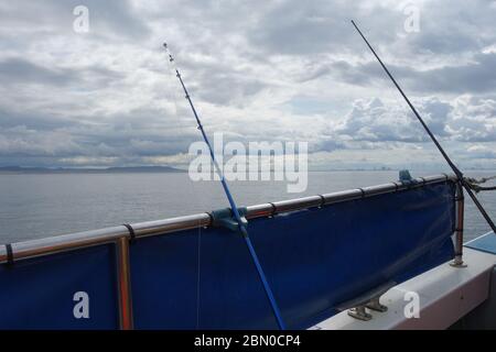 Canne da pesca sul lato di una barca da pesca charter nel Mare del Nord vicino a Hartlepool, Regno Unito. Foto Stock