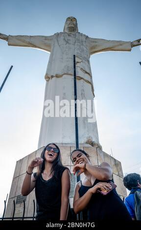 Due ragazze ispaniche che si trovano di fronte alla statua del Cristo del Rey a Cali Colombia Foto Stock