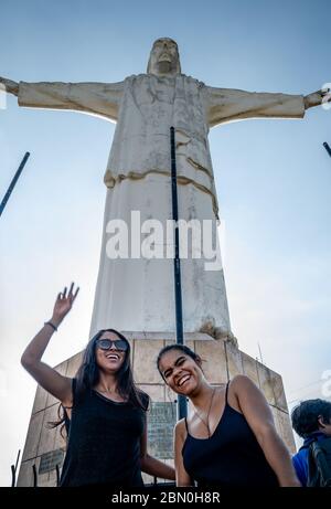 Due ragazze ispaniche che si trovano di fronte alla statua del Cristo del Rey a Cali Colombia Foto Stock