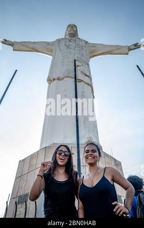 Due ragazze ispaniche che si trovano di fronte alla statua del Cristo del Rey a Cali Colombia Foto Stock