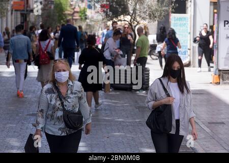 Atene, Grecia. 11 maggio 2020. La gente cammina a via Ermou ad Atene, Grecia, il 11 maggio 2020. La Grecia ha compiuto un altro passo lunedì verso la piena ripresa delle attività economiche e sociali riaprendo le prime scuole e negozi al dettaglio, due mesi dopo la loro chiusura per controllare la diffusione del romanzo coronavirus. Credit: Marios Lolos/Xinhua/Alamy Live News Foto Stock