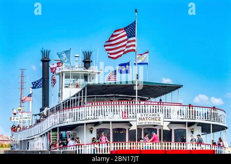 Turisti Natchez Steamboat Riverboat Flags Wharf Mississippi River New Orleans Louisiana. Uno degli ultimi battelli a vapore a ruota panoramica sul fiume e in t Foto Stock