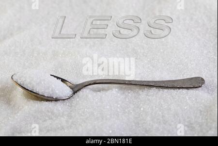 Meno testo, lo zucchero scorre su un cucchiaio, suggerendo un concetto di dieta e salute. Foto Stock