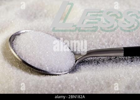 Meno testo, lo zucchero scorre su un cucchiaio, suggerendo un concetto di dieta e salute. Foto Stock