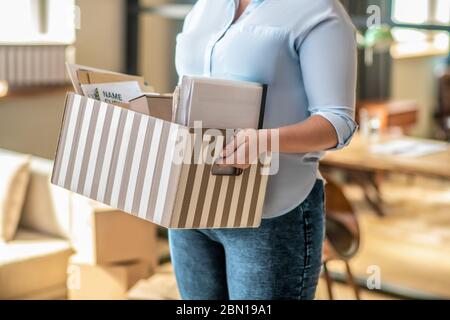 Primo piano immagine di una donna con un cartone in mano Foto Stock