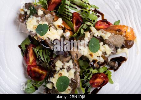 Crostini con funghi della foresta saltati, aglio, basilico e mozzarella. Tradizionale antipasto italiano su rucola, insalata di foglie di aragola. Foto Stock