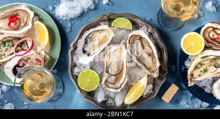 Ostriche con vari condimenti panorama, sparate dall'alto con vino, con limone e lime, pepe, cipolla Foto Stock