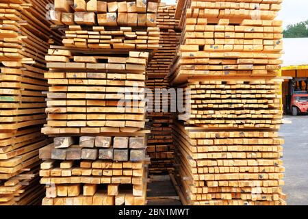 Pila di nuovi assi di legno. Primo piano. I listelli di legno per costruzioni sono venduti sul mercato. Foto Stock