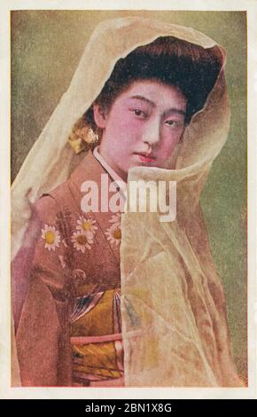 [ 1910 Giappone - Ritratto di una Geisha ] - giovane geisha in kimono con un velo. cartolina vintage del xx secolo. Foto Stock