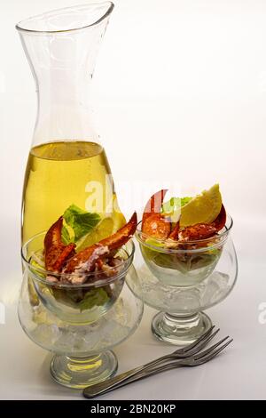 Caraffa di vino bianco e due cocktail di aragosta con forchette di pesce, isolato su bianco. Foto Stock