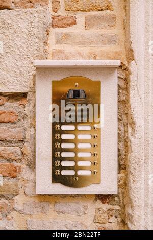 Primi piani di facciate di edifici a Venezia. Un vecchio citofono vintage e una casella postale su una parete di pietra. Sulla porta dove si sono collocate queste vecchie campane arrugginite. Foto Stock