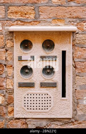 Primi piani di facciate di edifici a Venezia. Un vecchio citofono vintage e una casella postale su una parete di pietra. Sulla porta dove si sono collocate queste vecchie campane arrugginite. Foto Stock