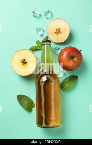 Composizione con sidro, mele e ghiaccio su fondo alla menta Foto Stock