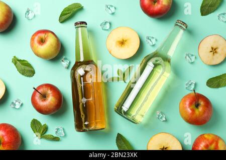 Composizione con sidro, mele e ghiaccio su fondo alla menta Foto Stock