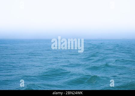 Mare blu con un tempo foggy al mattino Foto Stock