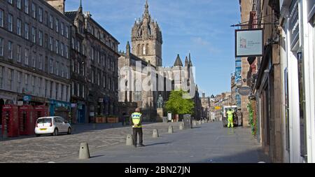 Centro di Edimburgo, Scozia, Regno Unito. 12 maggio 2020. Cinquantesimo giorno del Regno Unito Covid-19 Coronavirus Lockdown, strade e marciapiedi nella foto mostra una città senza turismo con pochissimo traffico o pedoni fuori e circa prima delle 9:45, due lavoratori essenziali a Royal Mile, Street Cleaner e Parking Attendant. Molti pub sono stati imbarcati e non si prevede che apriranno in Scozia fino a luglio. Credit: Arch White/Alamy Live News. Foto Stock