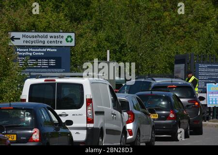 Le automobili accadiscano per usare il centro di riciclaggio della famiglia Havant, Hampshire, dopo l'annuncio dei programmi per portare il paese fuori dal blocco. Il personale del centro informa gli utenti che l'attesa per l'accesso è di circa 1.5 ore. Foto Stock