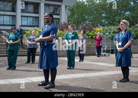 Gli infermieri si trovano al di fuori del St Thomas's Hospital nel centro di Londra per celebrare la Giornata internazionale degli infermieri. Foto Stock