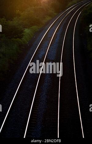 binari del treno illuminati al sole Foto Stock