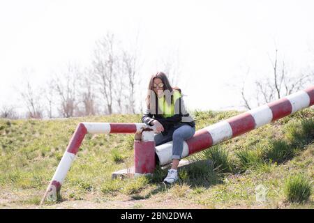 Felice hipster giovane ragazza che si diverte, saltando ragazza e sorridendo in abiti moderni, emotivo moment.Young ragazza su una passeggiata nel parco. Ragazza su una calda Foto Stock