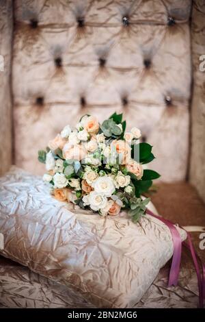 Lussuoso bouquet di rose crema rosa e bianca con bellissimi nastri in interni splendidi, fiori del giorno di nozze Foto Stock