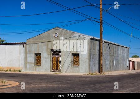 Vecchio edificio abbandonato ad angolo con ornate finestre in ferro battuto Foto Stock